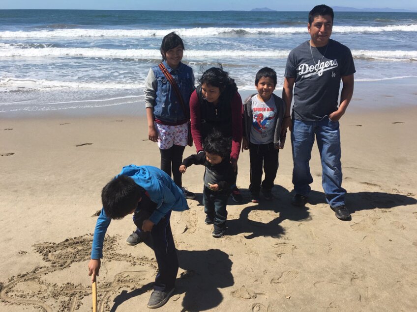 Tello family standing at the beach with Jordi (left), who is drawing a ninja in the sand. | Pilar Marrero (1920x1440)