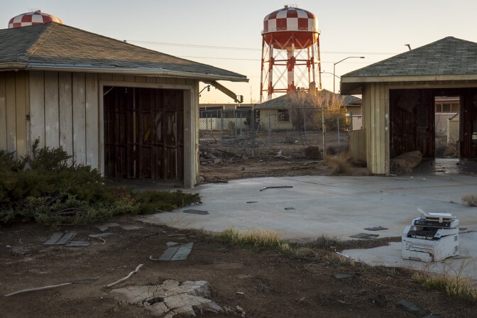 Empty garages of George Air Force Base's former housing with a water tower serving Victorville's Federal Correctional Complex in the distance. Photo: Kim Stringfellow.