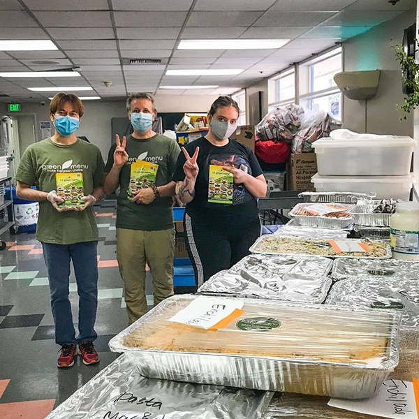 Hollywood Food Coalition (HoFoCo) volunteers pose next to containers of food.