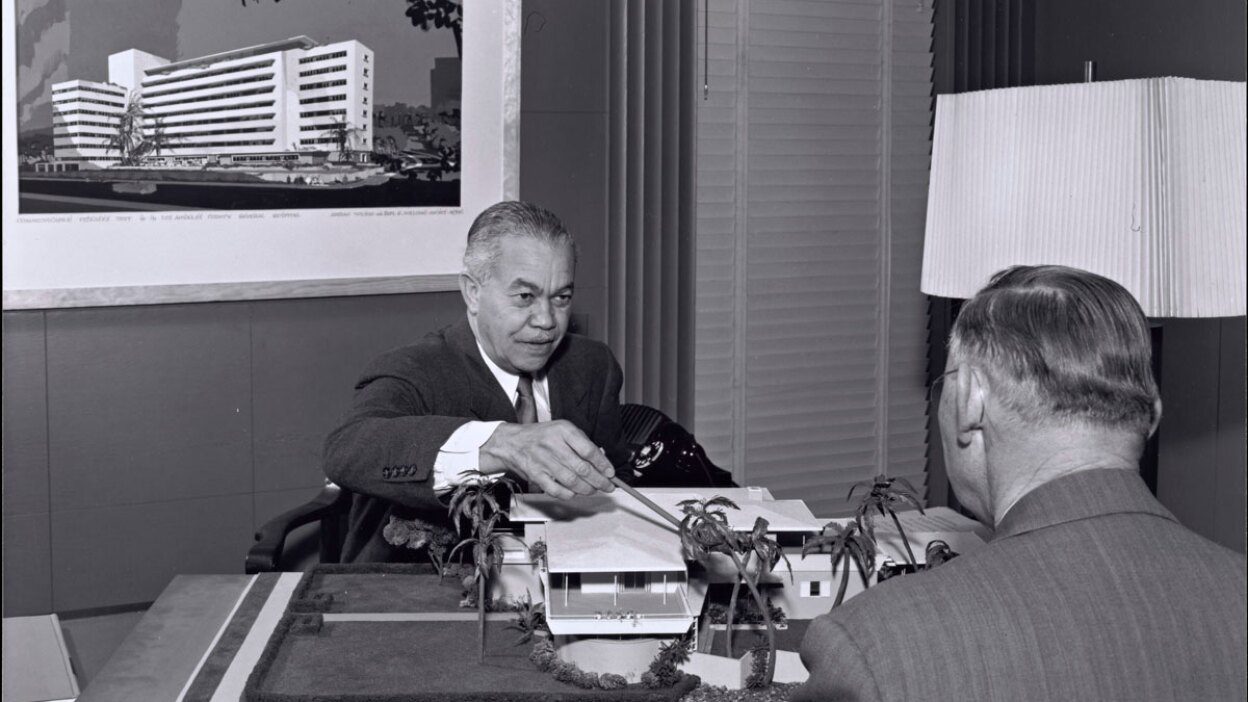 Paul R. Williams on the other side of the desk showing plans | J. Paul Getty Trust. Getty Research Institute, Los Angeles