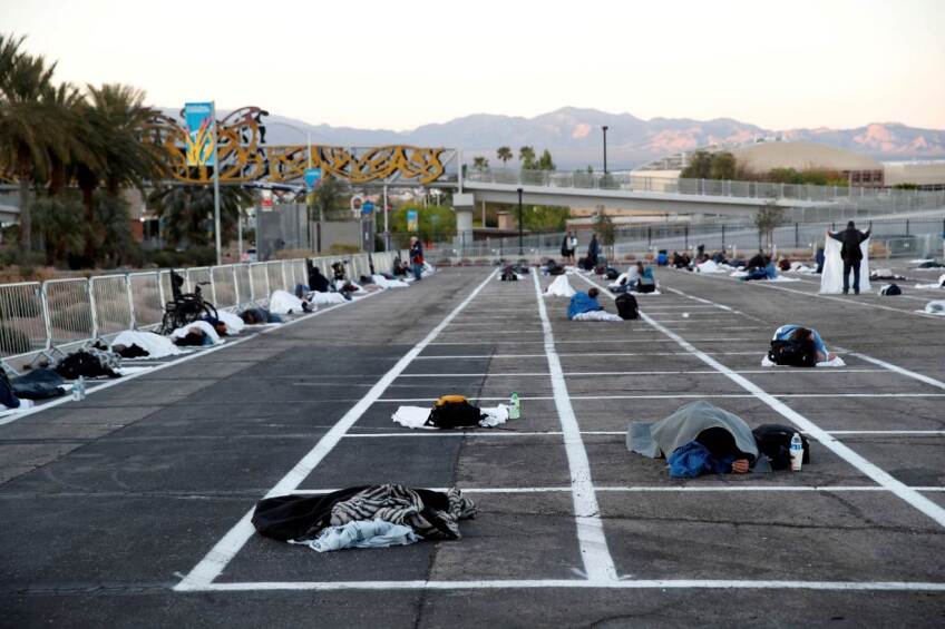 Homeless people sleep in a temporary parking lot shelter at Cashman Center, with spaces marked for social distancing to help slow the spread of coronavirus disease (COVID-19) in Las Vegas, Nevada, U.S. March 30, 2020. 