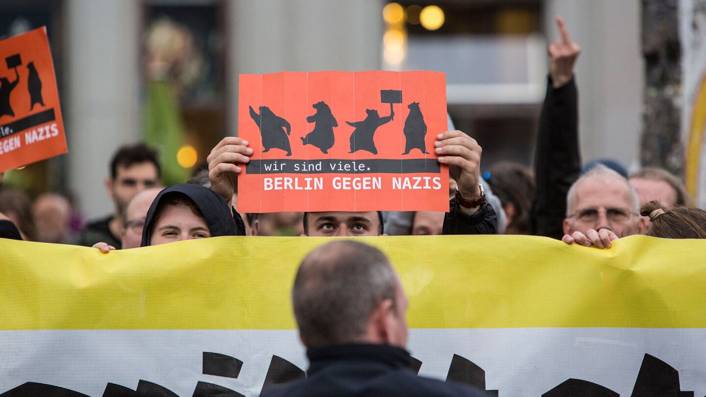 Germany Decides: Counter demonstrator holding a sign reading "Berlin against Nazis" at anti-Merkel rally.