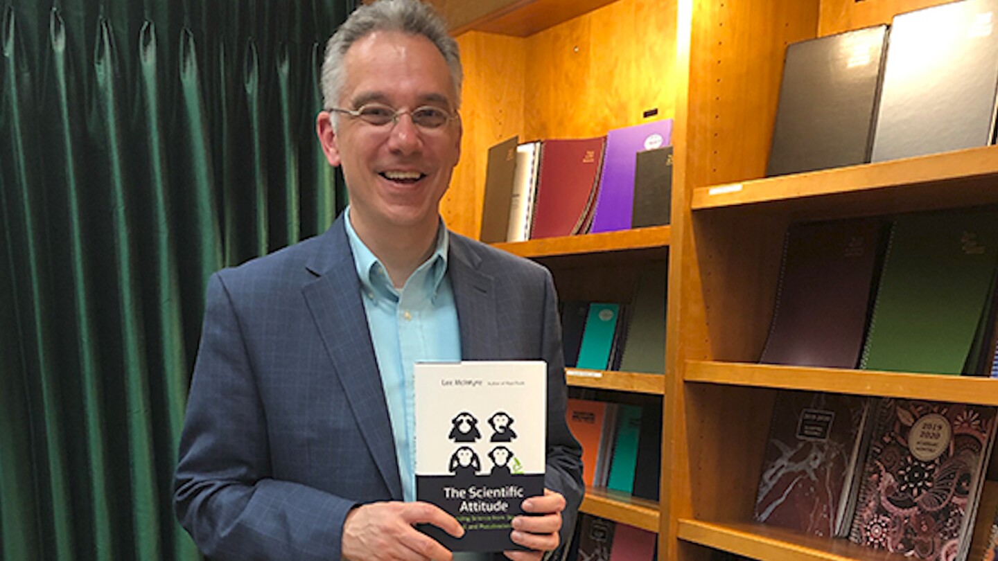 Author Lee McIntyre poses with his book, "The Scientific Attitude."