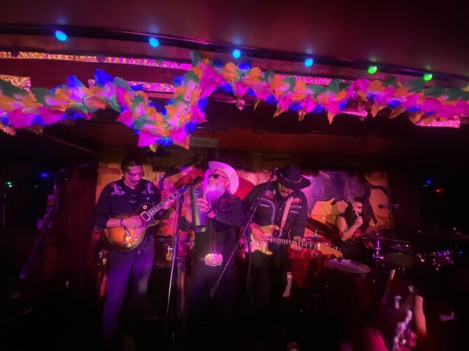 A cumbia band plays to a live audience.