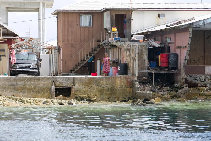 A woman looks at the ocean practically at her door in the Marshall Islands, which are at high risk due to sea level rise. | Courtesy of Thomson Reuters Foundation