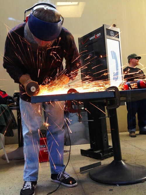 Francois Bar welds new stands for the second-hand public phones | Photo: Benjamin Stokes
