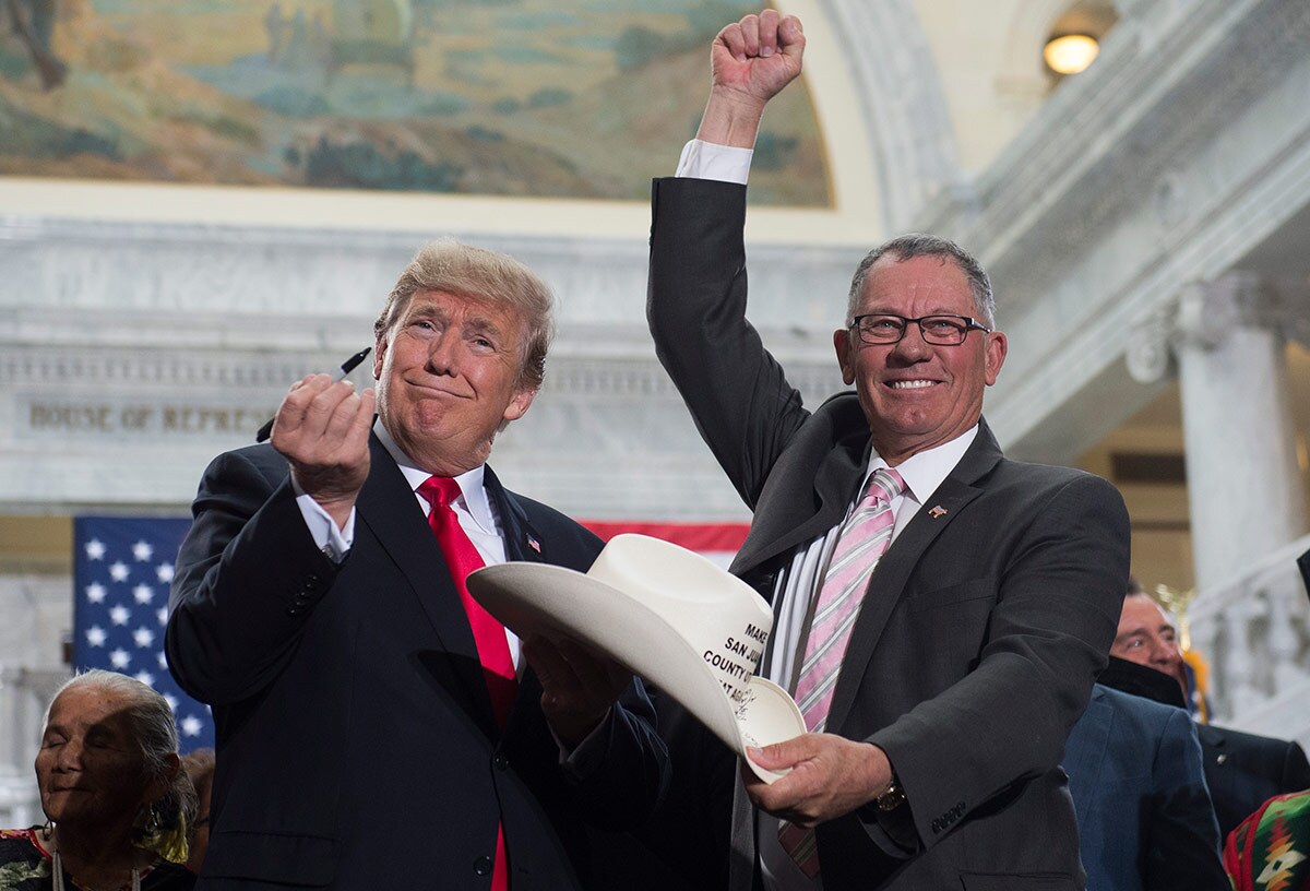 US President Donald Trump holds up a pen after signing the hat of Bruce Adams, Chairman of the San Juan County Commission, after signing a Presidential Proclamation shrinking Bears Ears and Grand Staircase-Escalante national monuments.SAUL LOEB/AFP Getty