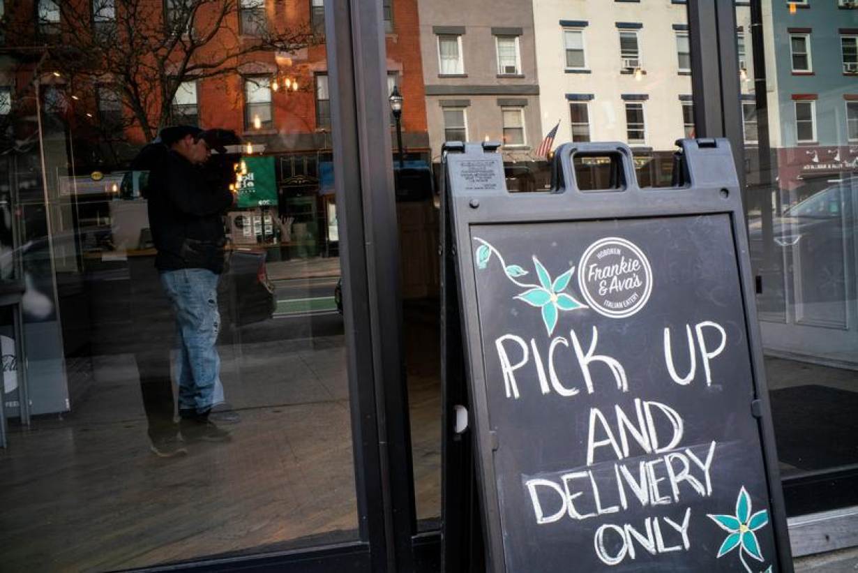 A customer waits inside a restaurant offering pick-up and delivery services only due to the outbreak of coronavirus disease (COVID-19), in Hoboken, New Jersey, U.S., March 16, 2020.