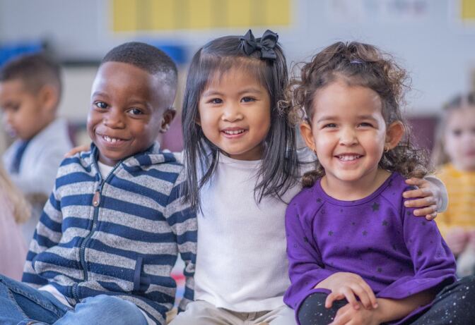 three small children sitting together