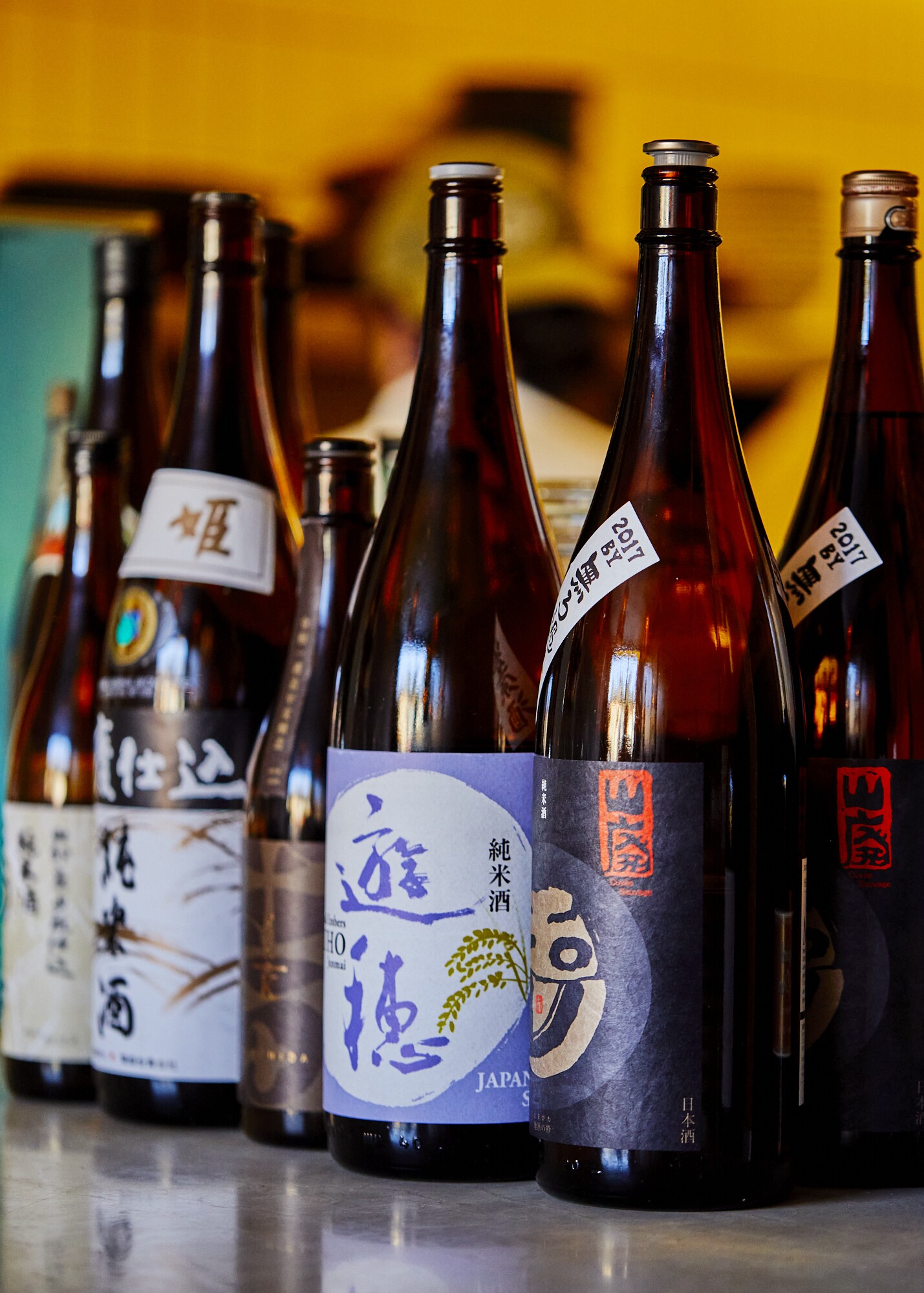 A selection of sake bottles set side by side.