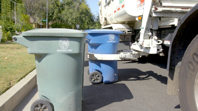 Recycling bins being picked up by truck | Still from "Life in Plastic: California's Recycling Woes"