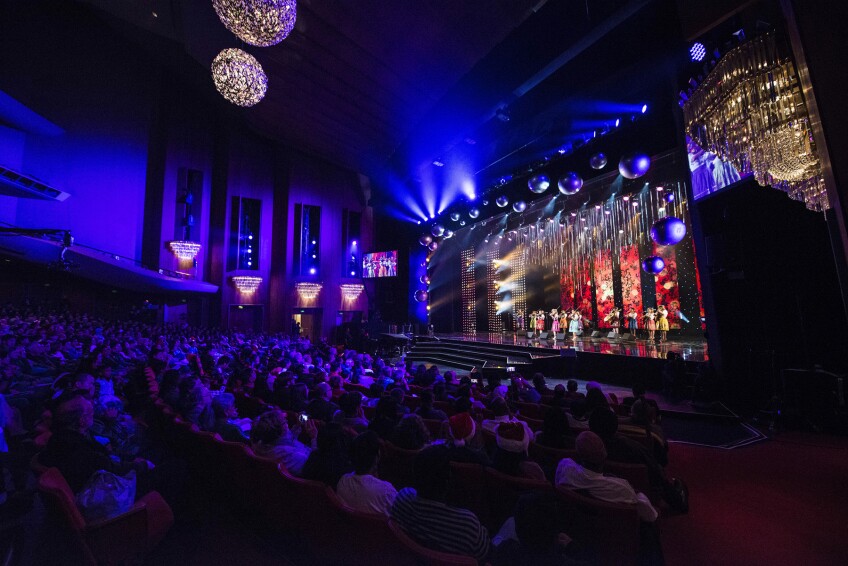 Audience watch in a darkened auditorium to watch performers during the L.A. County Holiday show.