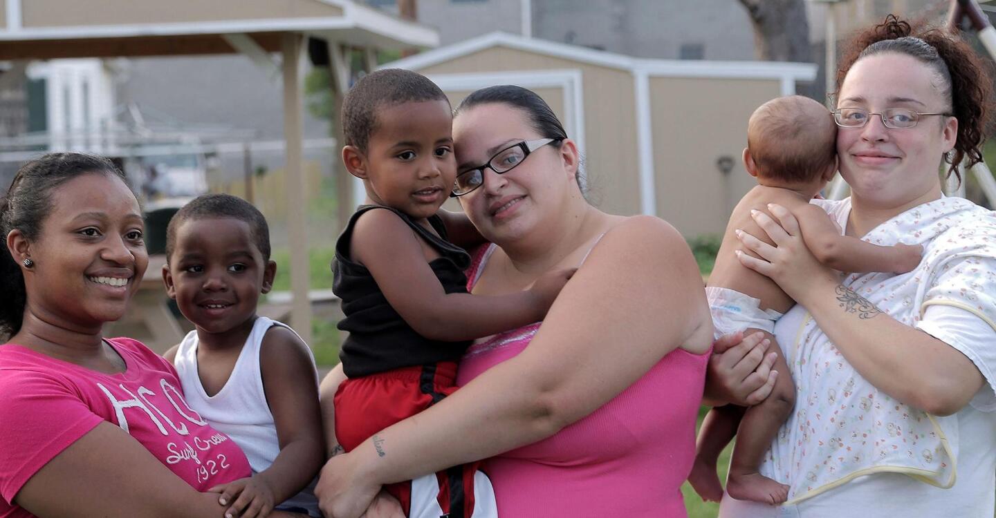 Three people hold toddlers and babies in their arms.