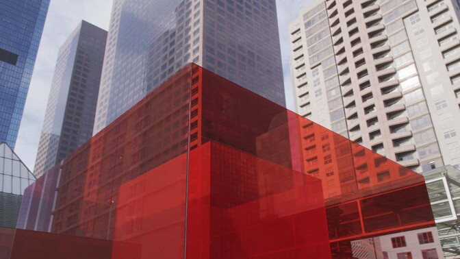 Larry Bell's "Bill and Coo at MOCA’s Nest" looking up at the downtown L.A. skyline. | Still from Artbound "Light & Space" ab s11