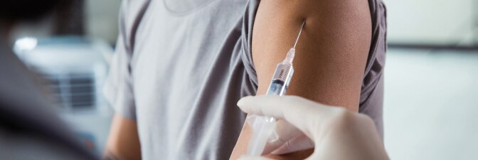 A health care worker vaccinates a person with a scar on their arm. | iStock via Getty Images
