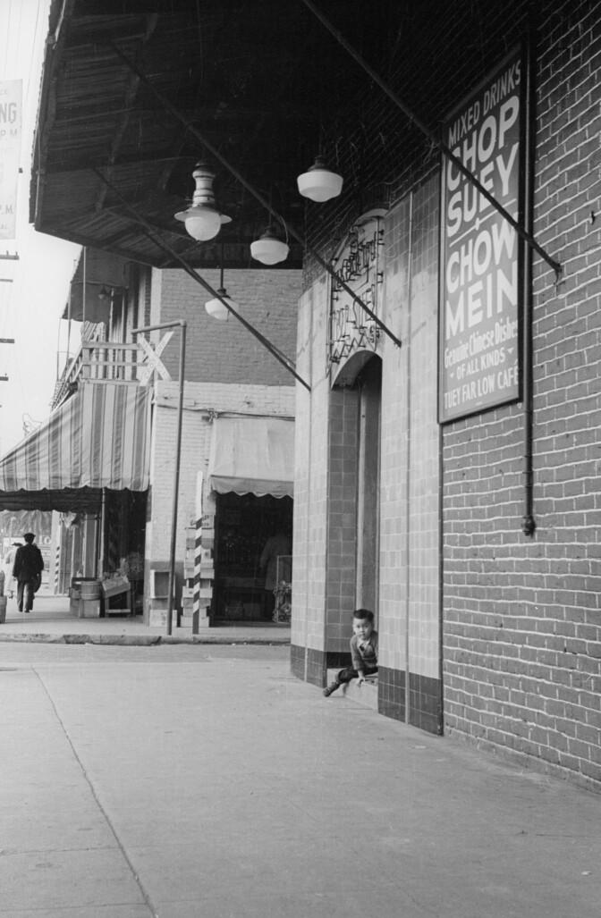 A young boy peeks outside an old Chinatown institution.