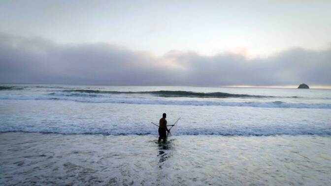 A member of Tolowa Dee-ni' Nation casts his net the beach. | Still from Tending Nature