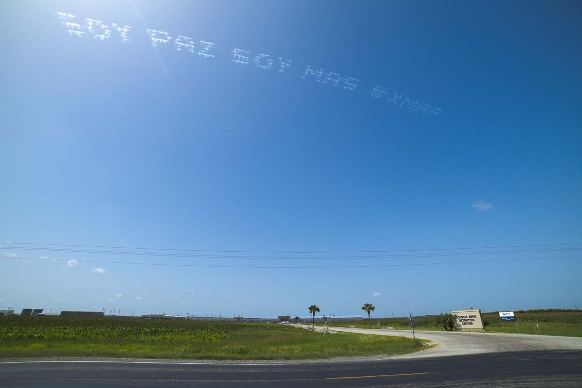 "SOY PAZ SOY MAS #XMAP" written in in the sky, contributed by Maria Gaspar over Coastal Bend Detention Center | Ronald L. Jones, In Plain Sight
