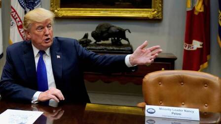 President Trump sitting between two empty chairs representing Congress's two top Democrats, Nancy Pelosi and Chuck Schumer, at a press conference for his proposed tax bill. | Democracy Now