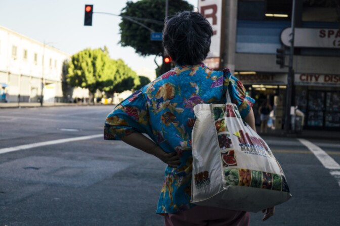 Woman with back turned crosses street | Chava Sanchez/LAist