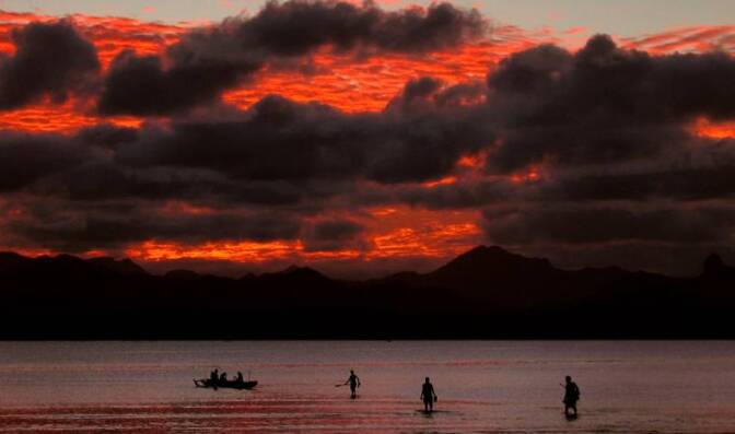 22-cisk3 left"> <p>ARCHIVE PHOTO: Fijian family board their canoe as a sunset lights up the sky behind an island's mountain range in Suva May 1, 2004. | REUTERS/David Gray DG/CP<