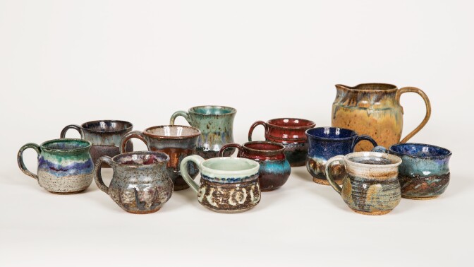 A collection of cups and a pitcher with handles.