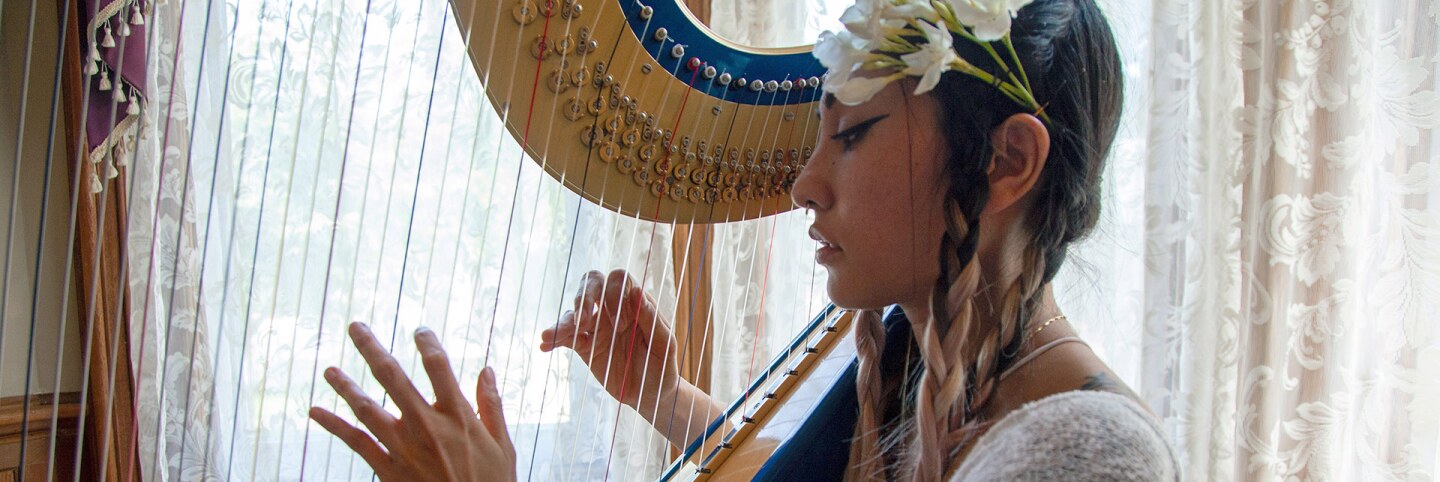 Low Leaf plays her harp inside the Perry House at Heritage Square Museum. | Azul Amaral