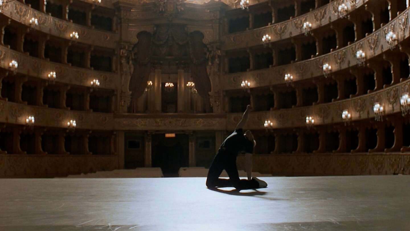 A dancer performs passionately in an empty performance hall. | "White Nights"