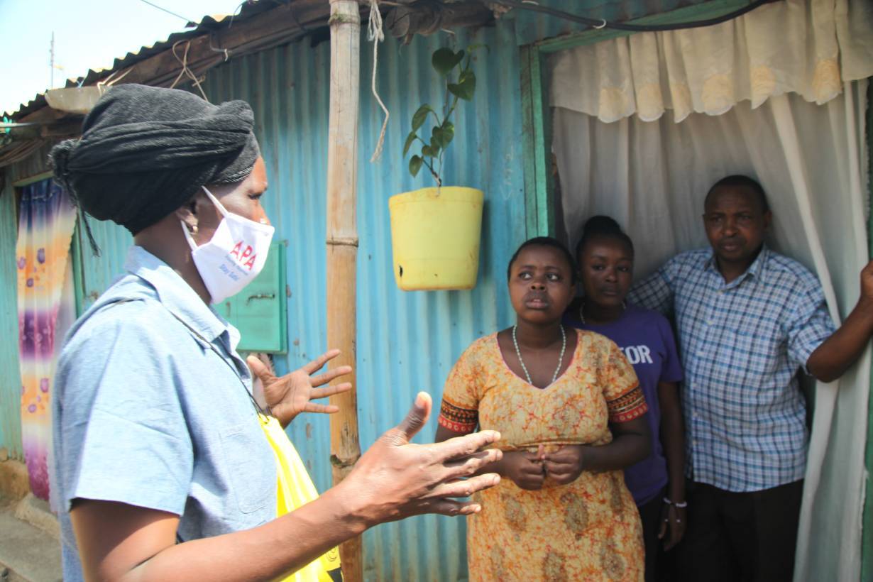 Community health volunteer Everlyne Akinyi Omondi talks to residents about the dangers of COVID-19 in Kawangware informal settlement in Nairobi, Kenya on May 27, 2020. | THOMSON REUTERS FOUNDATION/Nita Bhalla