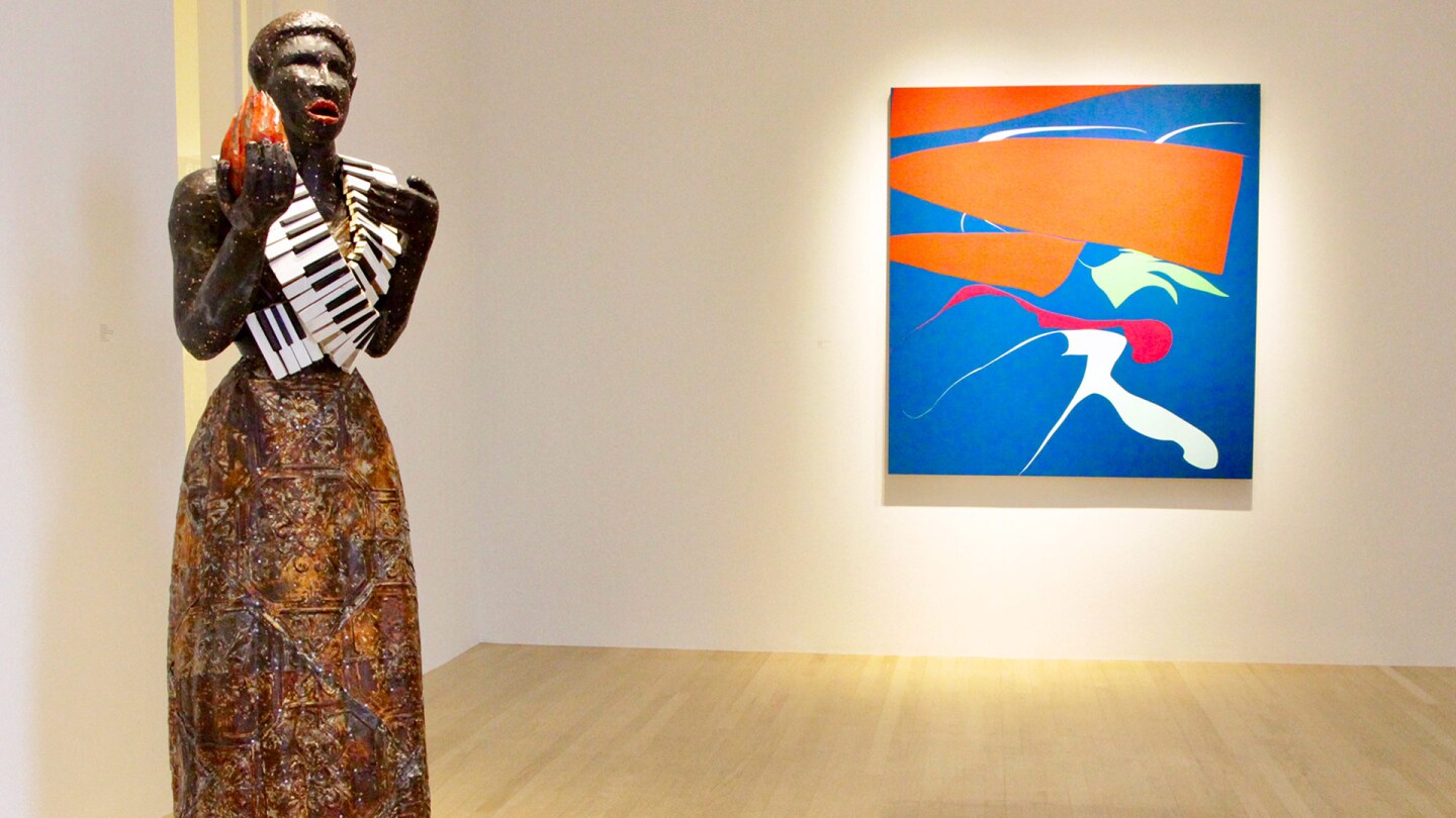 Alison Saar’s “Torch Song,” 2020 in wood, copper, ceiling tin, enamel paint, leather belts and vintage piano keys (72 x 22 x 26) next to Heather Gwen Martin’s “Touch” from 2020. Oil on linen, 60 x 56 in. | Jordan Riefe