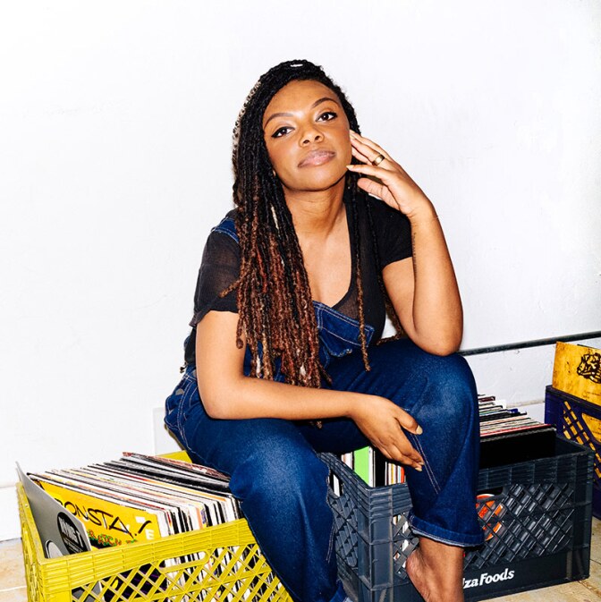 Jazzi McGilbert, founder of Reparations Club sits on boxes of records. | Daniel Redwood
