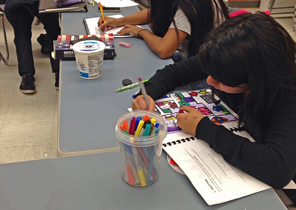 Cynthia references her Youth Voices Notebook as she draws her map.