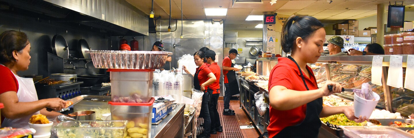 Workers behind the counter preparing and packaging the food for sale in the turo-turo section. | Jacqueline Lee