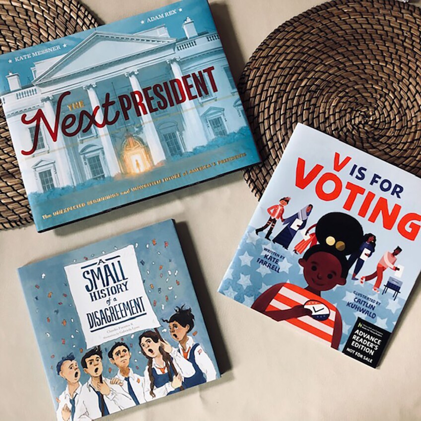 Three blue book covers of kids elections books. One features a cartoon of the White House, another a cartoon of a smiling black girl in a red and white top and the third a cartoon of a group of people talking