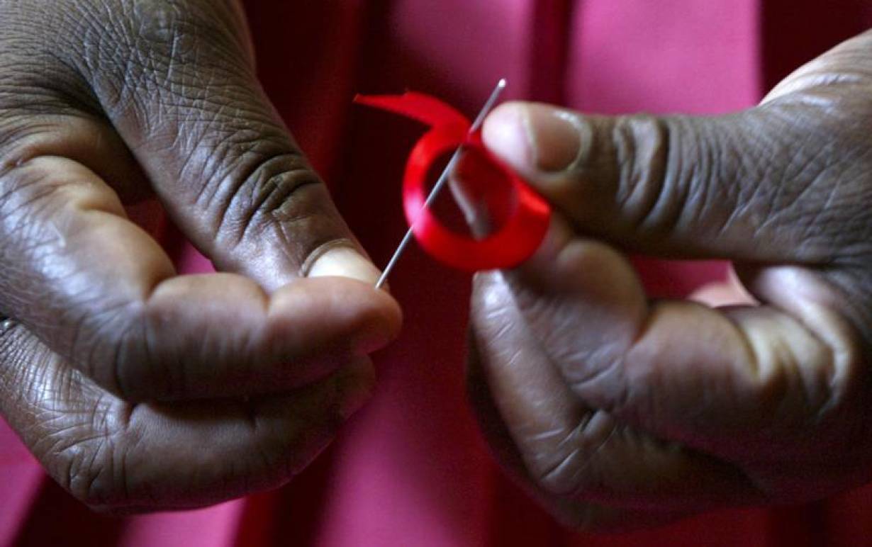 RCHIVE PHOTO: A Kenyan woman prepares ribbons ahead of World Aids Day in Nairobi, November 25, 2004. | REUTERS/Antony Njuguna