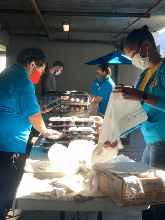 Clinica Romero workers package food.