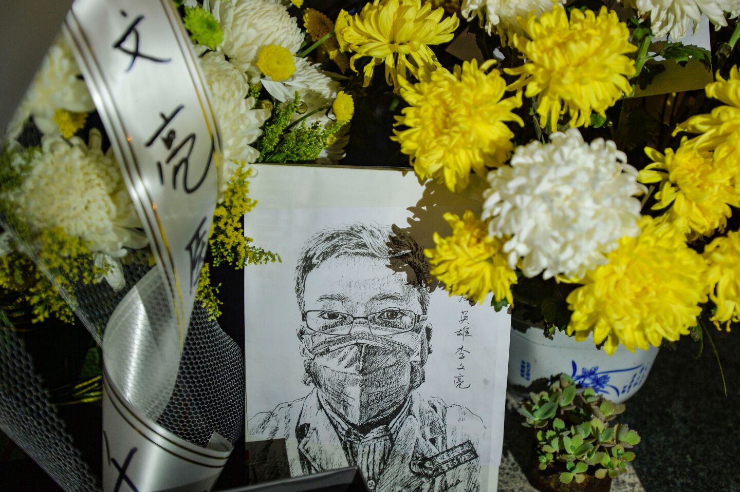 A memorial with flower bouquets honoring the late ophthalmologist Li Wenliang, who died after becoming infected with SARS-CoV-2, at the Houhu Branch of Wuhan Central Hospital in Wuhan in China's central Hubei province.