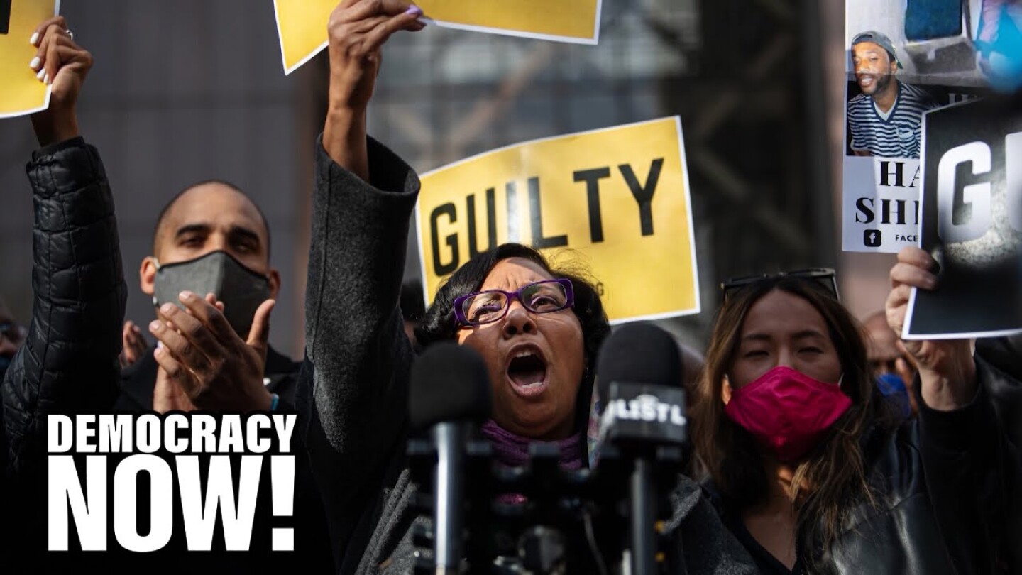 Demonstrators hold up signs that read "Guilty."