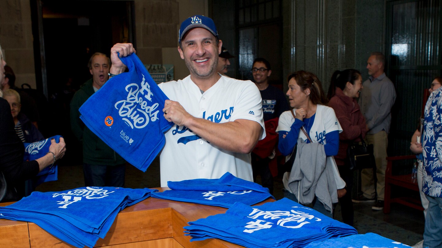 Dodgers fan, Shon Flores, enjoys special event giveaways following the screening at the Los Angeles Central Library on November 23, 2019.