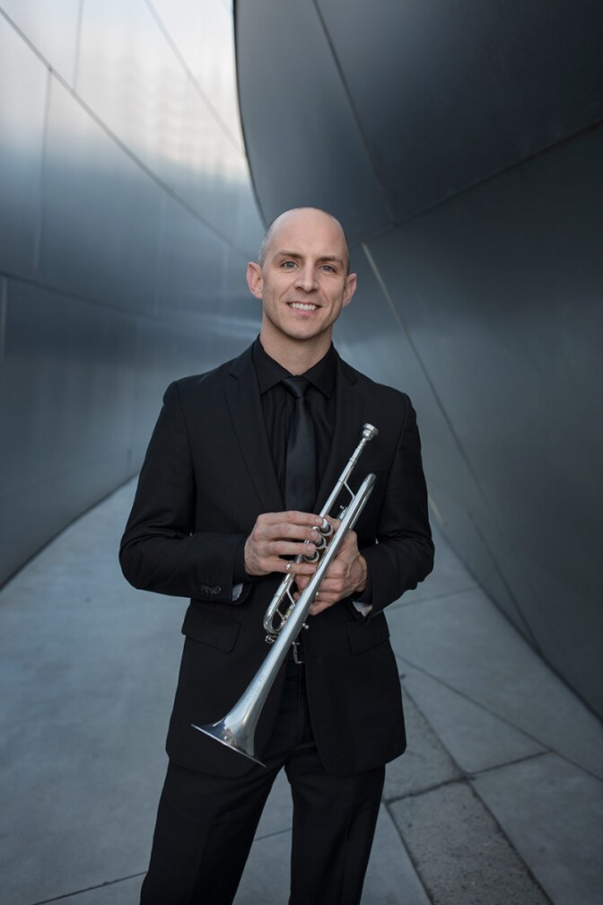 Tom Hooten poses holding his trumpet. | Ryan Hunter