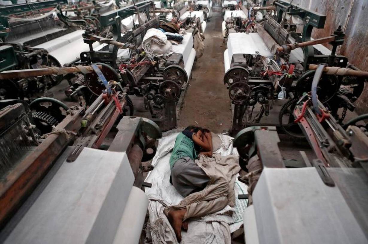 A migrant worker, who works in a textile loom, rests inside a loom after it was shut due to the 21-day nationwide lockdown to slow the spread of the coronavirus disease on the outskirts of Mumbai, India, April 1, 2020. | REUTERS/Francis Mascarenhas