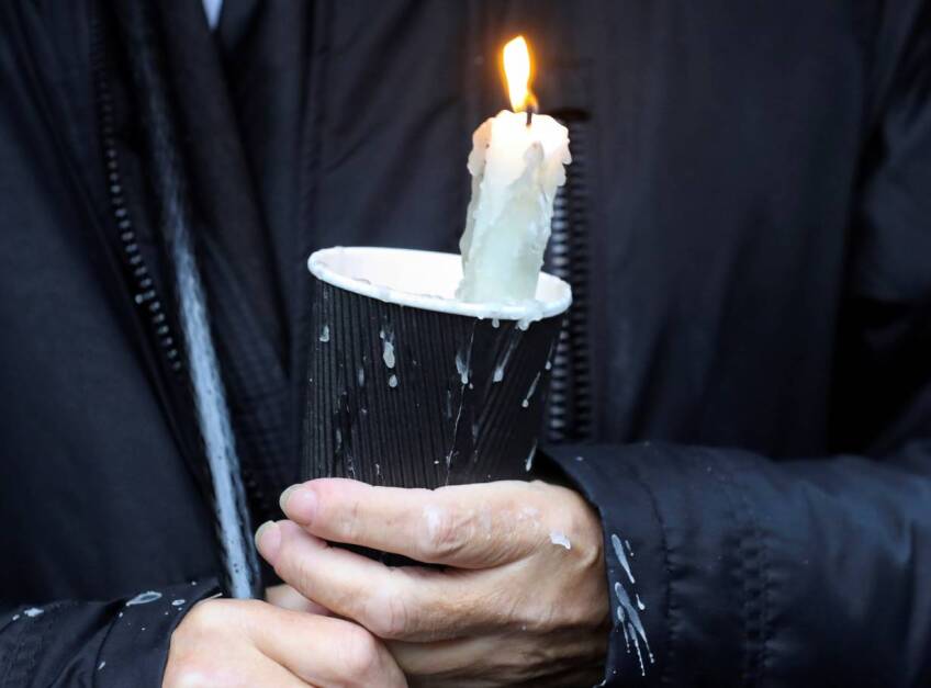 A mourner holds a candle outside St Eugene's Cathedral in Londonderry, Northern Ireland August 4, 2020. | REUTERS/Lorraine O'Sullivan