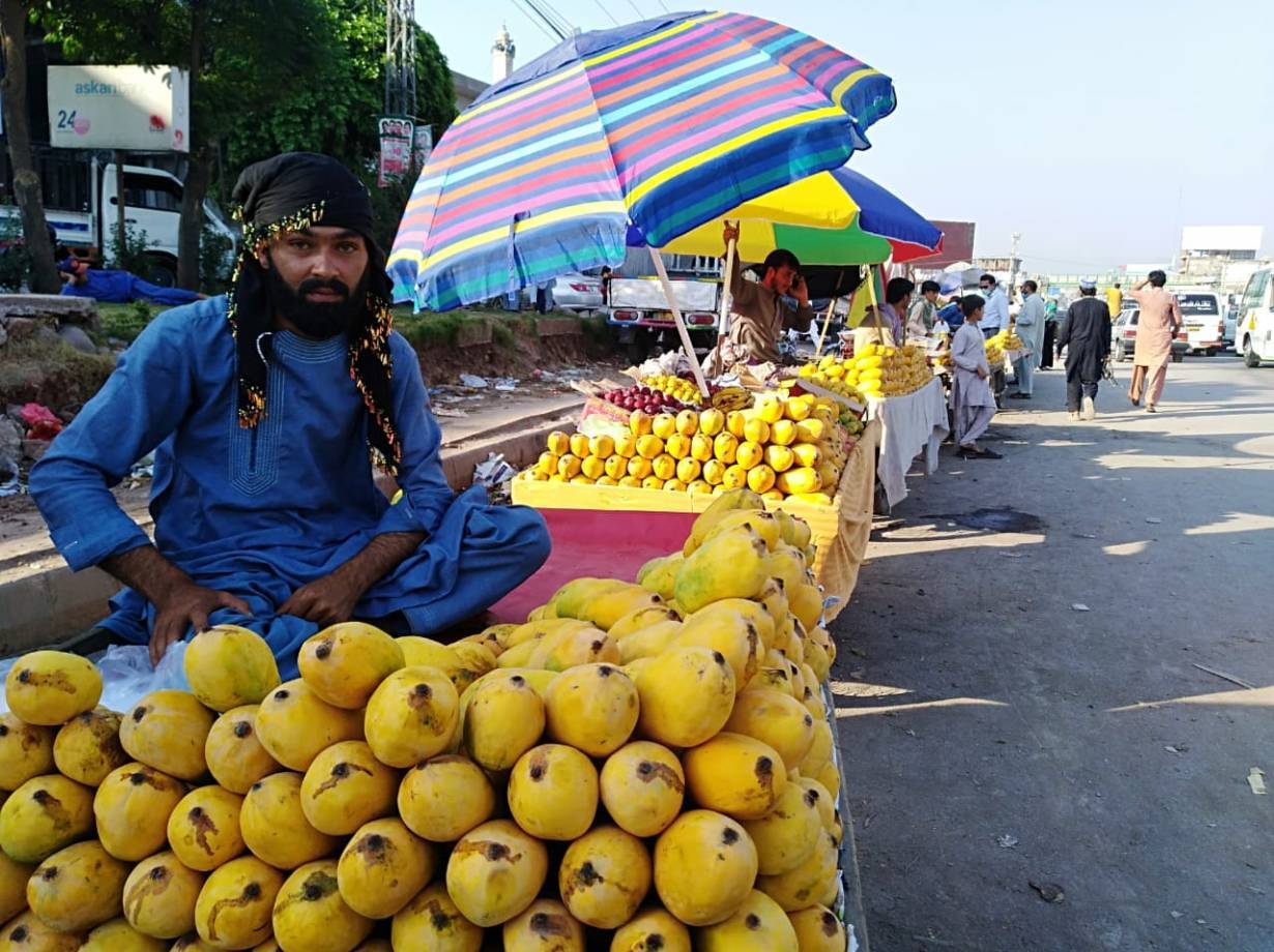 Mango vendors wait for customers in the Barakahu area of Islamabad, Pakistan’s capital, on June 16, 2020. | Thomson Reuters Foundation/Peer Muhammad