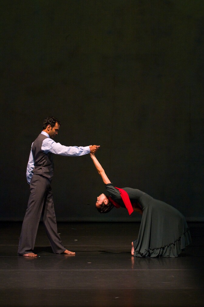 A barefoot man and woman dance together.