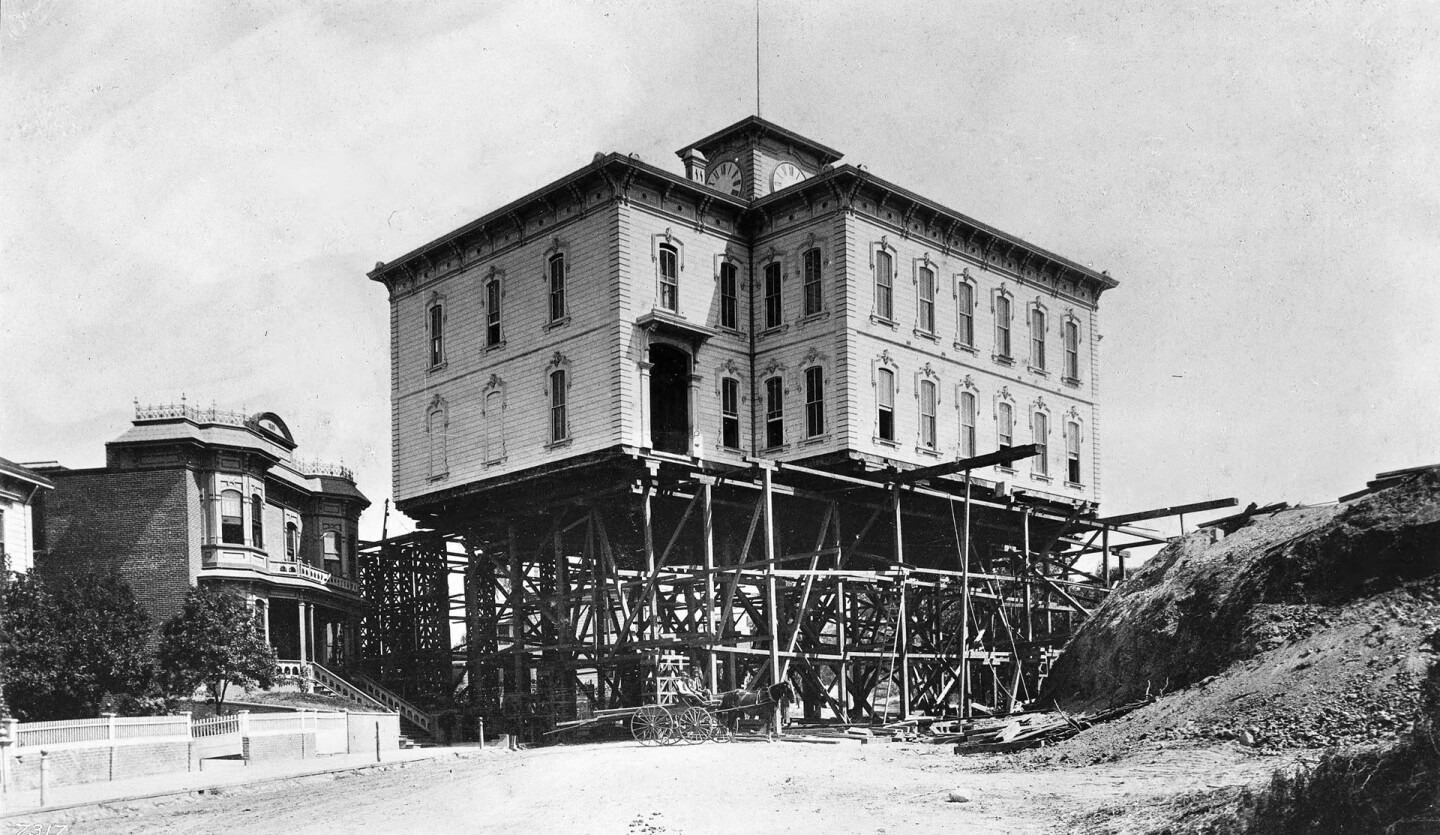 In 1886, house-moving contractors hoisted the Los Angeles Central School building on stilts and moved it across the city. Courtesy of the USC Libraries - California Historical Society Collection.