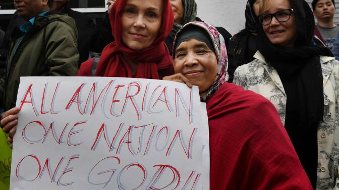 Members of the Islamic and other religious communities listen during a solidarity rally held in response to President Donald Trump's new executive order on refugees.