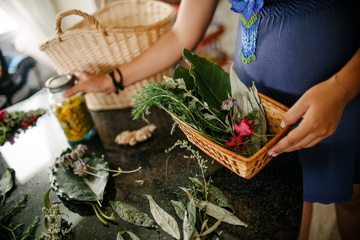Panquetzani arranges flowers and herbs on a table. | Samanta Helou Hernandez