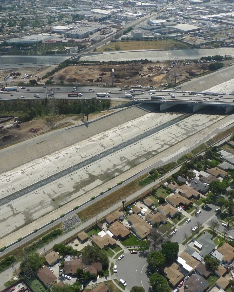 A freeway crosses a concretized river bed. This is an aerial view of the Los Angeles River as it meets the Rio Hondo.