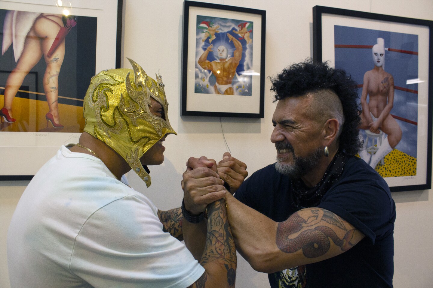Two men pretend to tussle with one wearing a lucha libre mask.