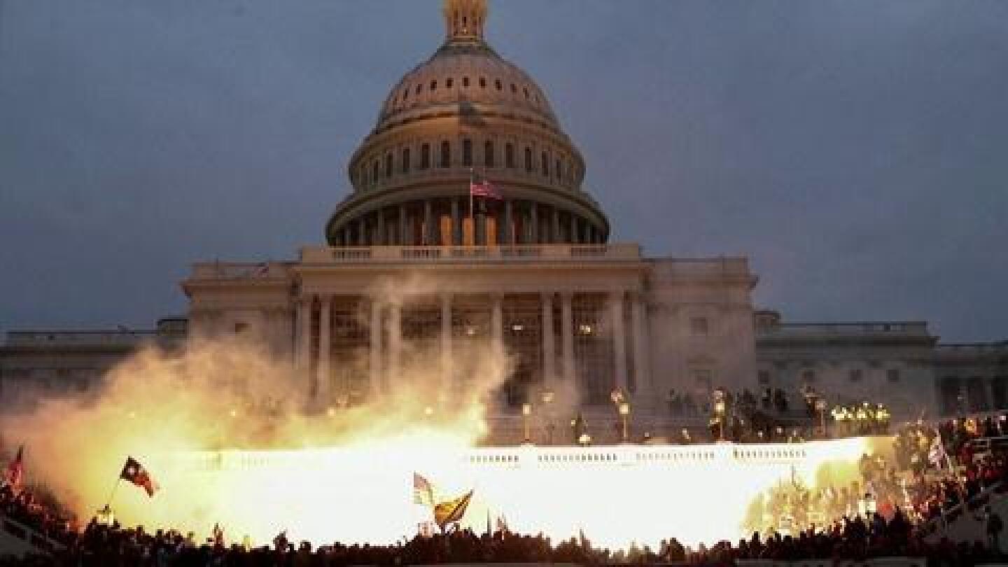 Fire erupts amidst a mob outside the U.S. Capitol.